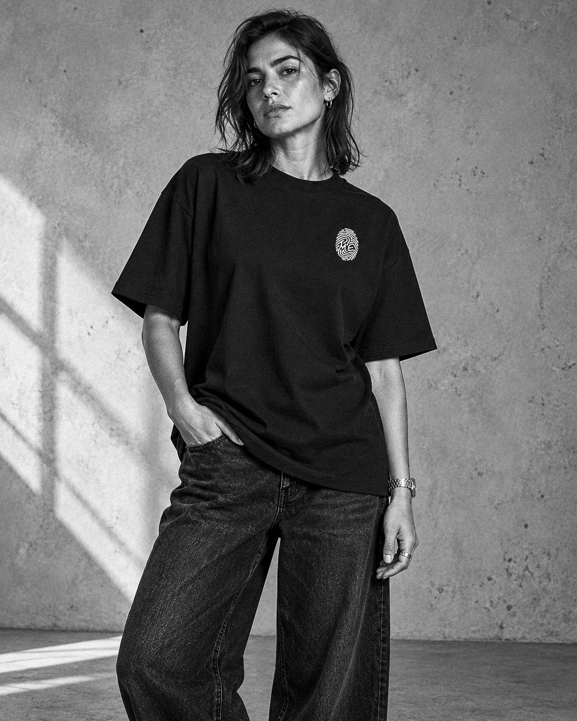 L’Empreinte — t-shirt oversize noir porté par une femme debout